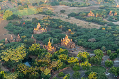 Panoramic view of pagodas in green fields in bagan during sunrise