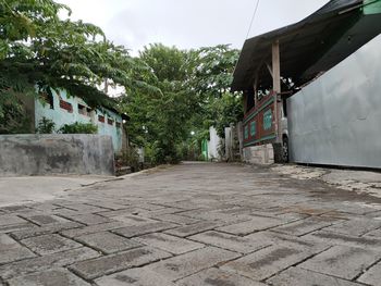 Surface level of footpath by building against sky