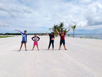 People standing on beach against sky