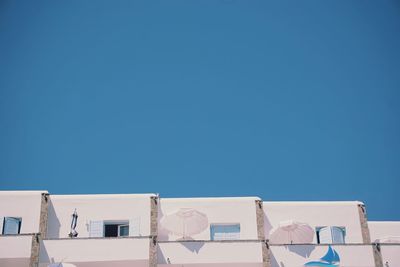 Low angle view of buildings against clear blue sky