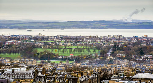 High angle view of townscape by sea against sky