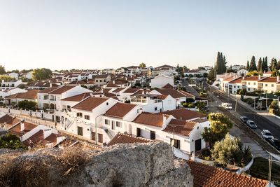 High angle view of houses in town against clear sky