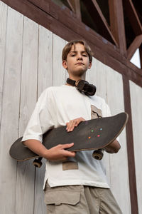 Portrait of young man standing against wall