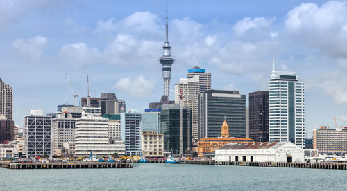 Buildings in city against cloudy sky