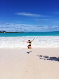 Full length of woman jumping at beach