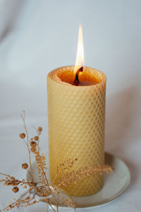 Close-up of illuminated candle on table