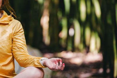 Close-up of the hand of woman relaxing in lotus pose in the park. 