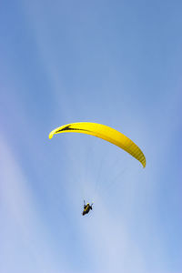 Paraglider flying flying in the blue clear sky