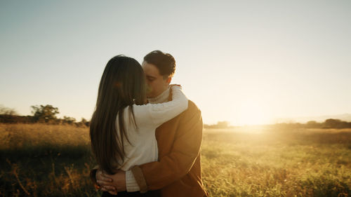 Romantic couple hugging outdoor at sunset light