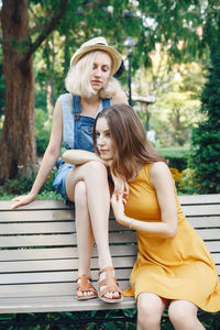 Female friends sitting on bench at park