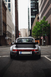 Cars on road by buildings in city