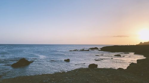 Scenic view of sea against clear sky at sunset