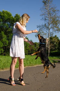 Woman with dog standing on street