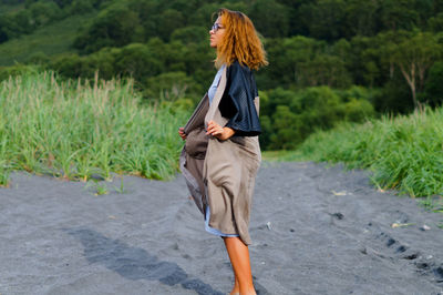 Fashionable mid adult woman standing on sand