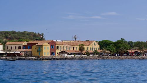 Buildings by sea against sky in city