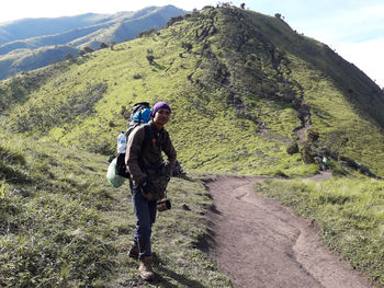 Full length rear view of man climbing on mountain