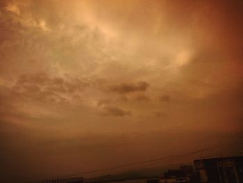 Low angle view of silhouette buildings against dramatic sky