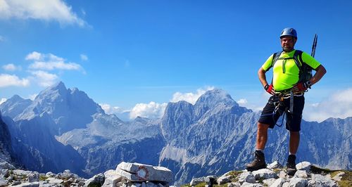 Man standing on snowcapped mountain against sky