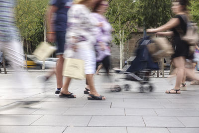 Blurred motion people walking on footpath