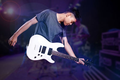 Midsection of man playing guitar