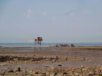 Traditional carrelet on beach against sky