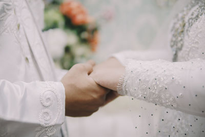 Midsection of bride holding wedding dress