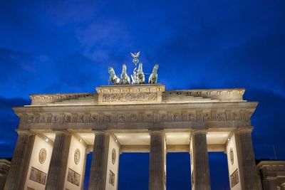 Low angle view of illuminated brandenburg gate against sky at dusk