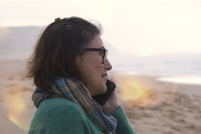 Side view of young woman standing at beach