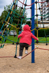 A small child on the jungle gym with net in a playground