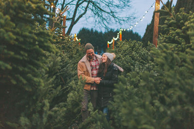 People standing by trees against plants