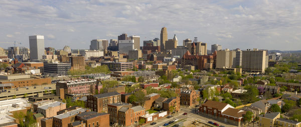 Aerial view of buildings in city against sky