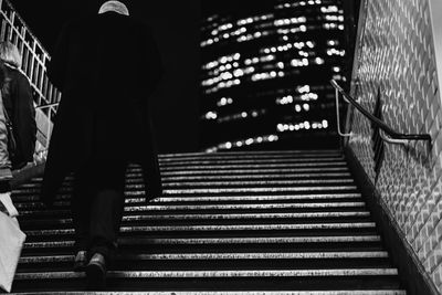 Rear view of man standing on staircase
