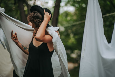 Midsection of woman with umbrella standing against blurred background