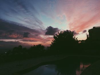 Scenic view of silhouette trees against dramatic sky