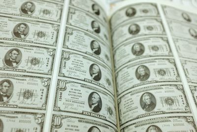 Full frame shot of us paper currencies printed on book