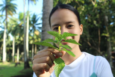 Young woman holding plant