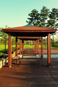 Empty bench in park against clear sky