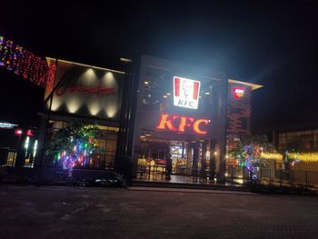 Illuminated sign on street in city at night