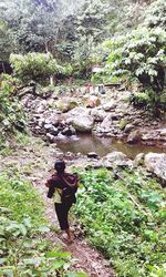 Rear view of woman standing by river