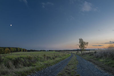 Road amidst field against sky