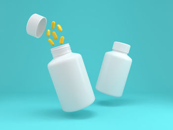 Close-up of white bottle against blue background