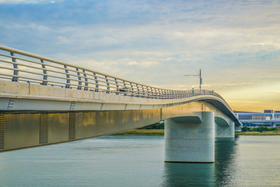 Bridge over river against sky during sunset