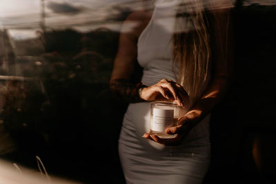 Cropped hand of woman using candles 