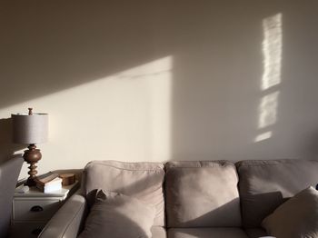 Sofa against wall with sunlight at home