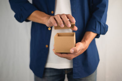 Midsection of man holding camera while standing in box