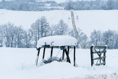 Snow covered old shack near road