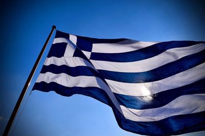 Low angle view of greek flag against clear sky