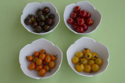 High angle view of four bowls with variety of tomatoes
