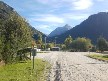 Road by mountains against sky