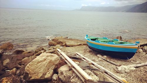 Boat moored at shore against sky